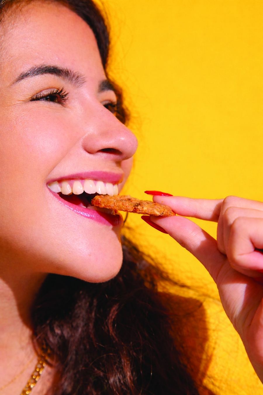 Woman enjoying an O'ts crispy oatmeal cookie